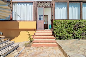 A building with a wooden door, a set of stone steps leading to the entrance, and a hedge to the right. - 
43
Villa Notte di Stelle, Golfo Aranci, Sardinia (Sardegna)
