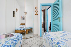 A bedroom with two beds, a wardrobe, and a mirror. - 
43
Villa Notte di Stelle, Golfo Aranci, Sardinia (Sardegna)