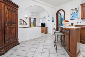 A spacious kitchen with a tiled floor, wooden cabinets, a bar area, and a television. - 
43
Villa Notte di Stelle, Golfo Aranci, Sardinia (Sardegna)