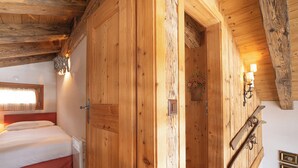 Quarto de madeira com uma cama, um guarda-roupa de madeira e um suporte para esquis.