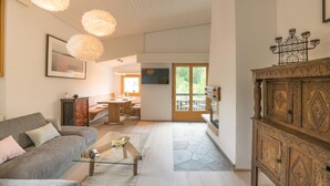 Een moderne woonkamer met een bank, salontafel en hanglampen.