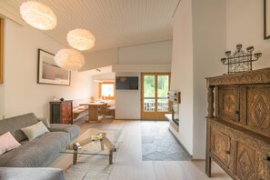 Ein modernes Wohnzimmer mit Sofa, Couchtisch und Pendelleuchten.