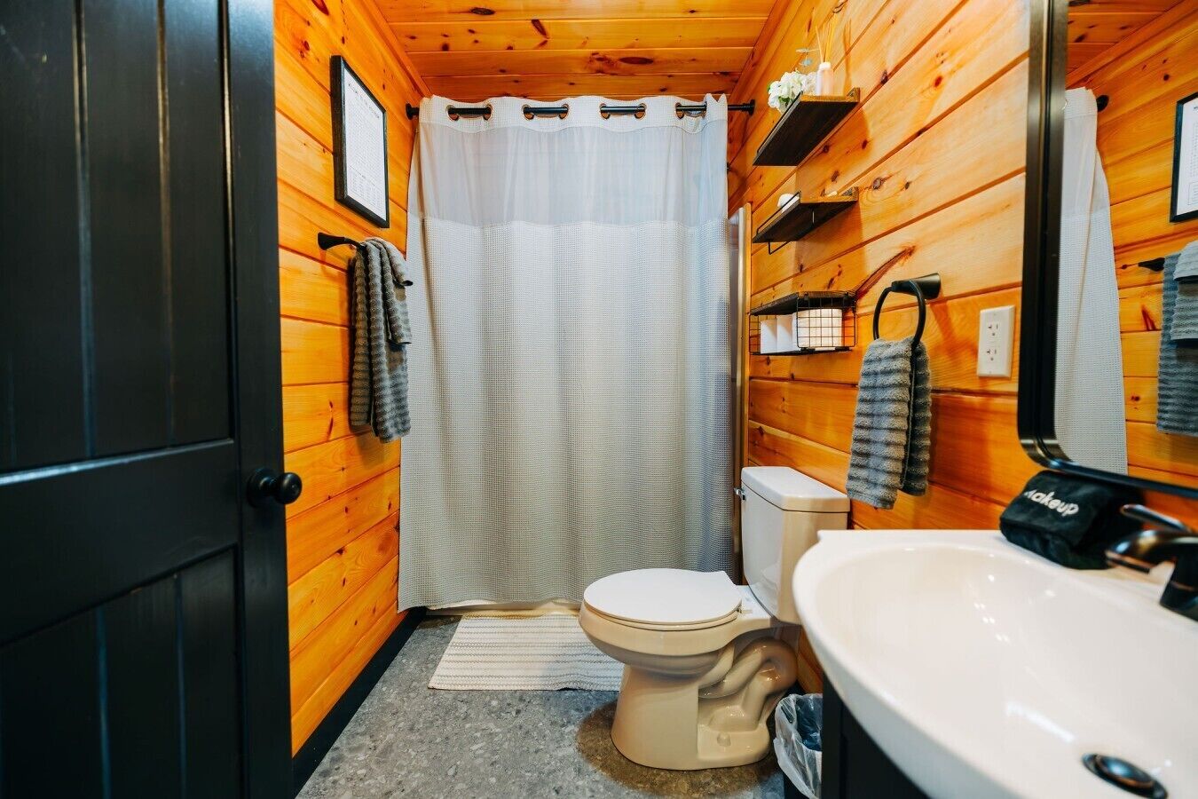 Un baño pequeño con inodoro, lavamanos y cortina de ducha.