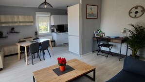 Eine moderne Wohnung mit Essbereich, Küche und einer kleinen Arbeitsnische.