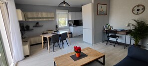 Eine moderne Wohnung mit Essbereich, Küche und einer kleinen Arbeitsnische.