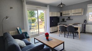 Ein modernes Wohnzimmer mit einer Couch, einem Couchtisch und einem Essbereich mit Stühlen und einem Tisch.