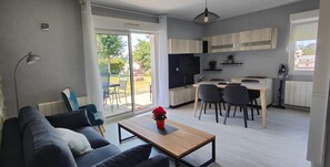Ein modernes Wohnzimmer mit einer Couch, einem Couchtisch und einem Essbereich mit Stühlen und einem Tisch.