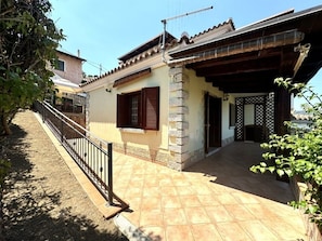 A residential property with a tiled patio, a wooden pergola, and a stone wall. - Vacation House Bellavista - Budoni - Muriscuvò (budoni)
