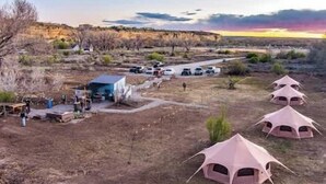 A campsite with tents, a small building, and vehicles. - Journey South West Tent 3 (Farmington)