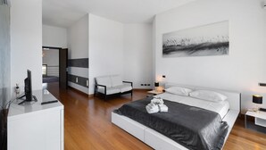 Une chambre à coucher moderne avec un lit, des tables de chevet, un bureau et une chaise.