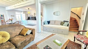 Una sala de estar con un sofá, una mesa de centro y una escalera.
