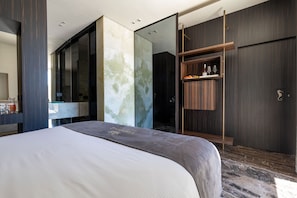 A modern hotel room with a large bed, a walk-in closet, and a glass partition wall. - Harbour - Luxury Room Pearl (Trani)