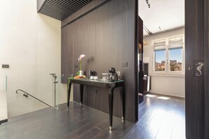 Una cocina moderna con una mesa de madera oscura, un florero con flores y vistas a la ciudad a través de amplios ventanales.