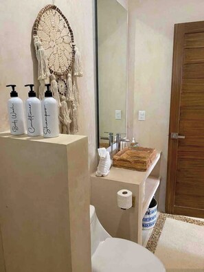 Un bagno con un mobile lavabo, un portafortuna e articoli da toilette.