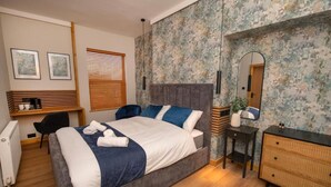 A bedroom with a bed, bedside table, dresser, chair, and a desk with a chair. - Amber Serviced Accommodation Rooms (Hull)