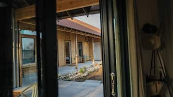 Una cabaña de madera con un porche, una silla y una ventana.