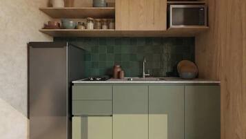 A modern kitchen with a refrigerator, microwave, and green tiled backsplash.