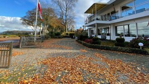 Un bâtiment moderne doté d’un toit plat, de grandes fenêtres et d’un mât pour drapeau.