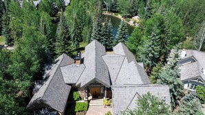 A large, multi-story house surrounded by dense forest, with a prominent central chimney and a well-maintained driveway. - BRAND NEW - Luxury Beaver Creek Mountain Retreat - Sleeps 16 (Edwards)