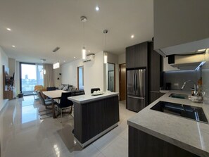 A modern kitchen with a central island, stainless steel appliances, and pendant lighting.