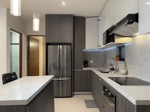 A modern kitchen with a stainless steel refrigerator, a built-in oven, and a countertop sink. - lujoso 2 cuartos bakara (Monterrey)