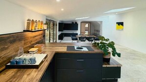 Una cocina moderna con encimera de madera, armarios negros y una isla central.