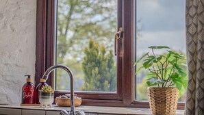 A kitchen with a window, a sink, and a potted plant. - Two Exmoor Cottages with Hot Tub | Sleeps 10 (Dulverton)