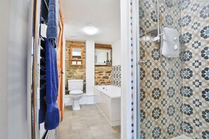A bathroom with a toilet, sink, and shower.