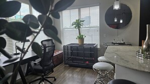 Une cuisine moderne avec un plan de travail en marbre, une plante en pot et une caisse en métal noir.