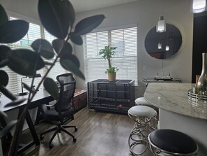 Eine moderne Küche mit Marmorarbeitsplatte, einem Blumentopf und einer schwarzen Metallkiste.