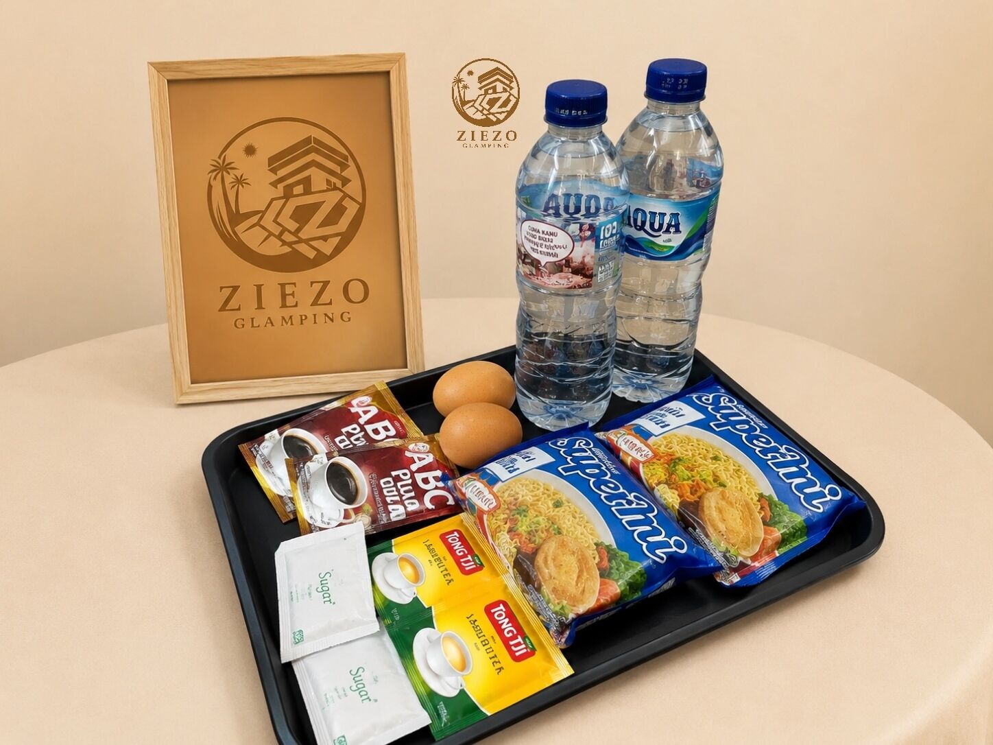 A tray with food items, two water bottles, a framed picture, and a logo.