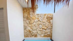 A small pool with a stone wall, a pink flamingo float, and a logo in the corner. - Glamping Ziezo  (Kabupaten Karanganyar)