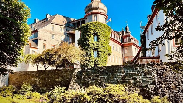 Ein historisches Gebäude mit einer markanten Kuppel und einer mit Efeu bewachsenen Fassade.