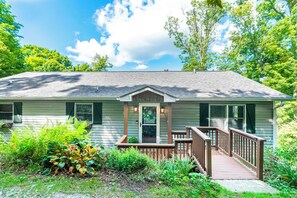 A single-story house with a front porch, a small deck, and a front door. - Sugar on the Rocks: Mountain View, Hot Tub, Pool Table, Fire-Pit, Pet Friendly (Sugar Mountain)
