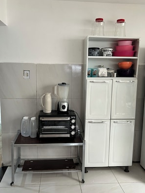 A kitchenette with a toaster, blender, and a refrigerator.