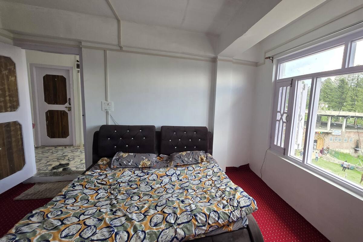 Quarto com cama, janela e porta.
