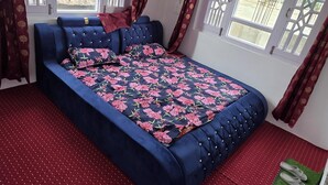 Quarto com uma cama grande, um ventilador de teto e vista para o exterior.