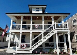 A two-story house with a balcony, a staircase, and American flags. - New renovation in the heart of Ventnor Heights (Ventnor City)