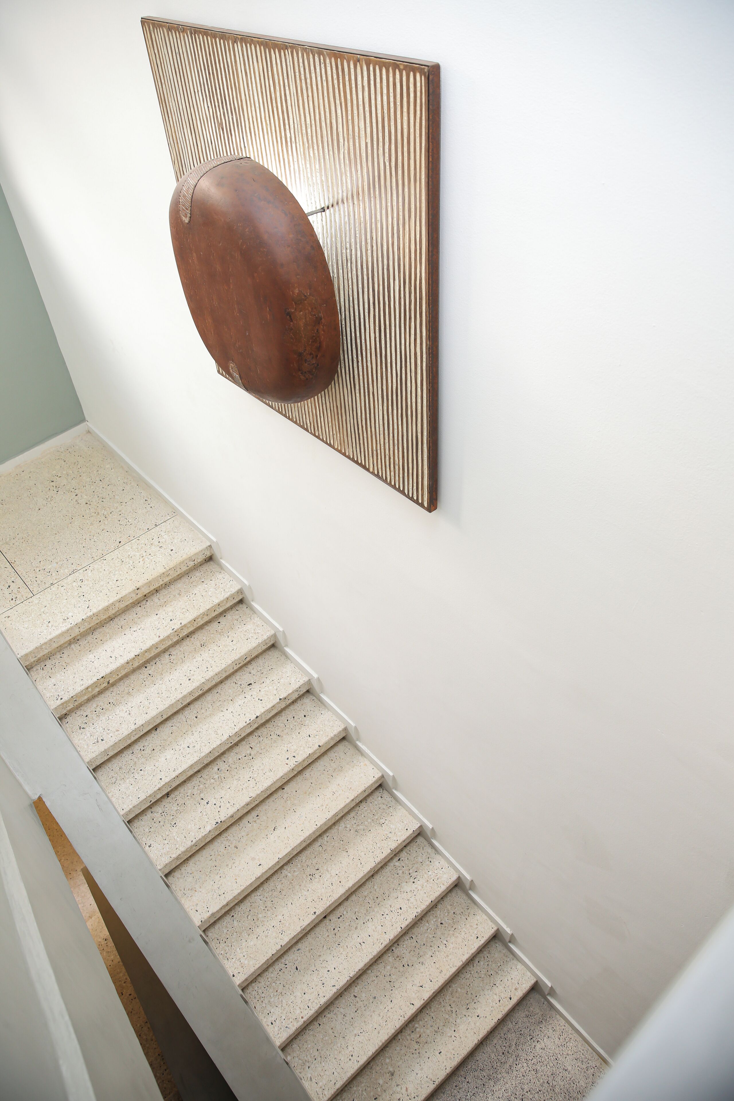A staircase with a speckled floor and a wall-mounted object.