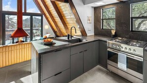 Una cocina moderna con una isla grande, estufa y vistas al exterior.