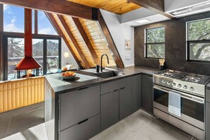 Una cuina moderna amb una illa gran, una estufa i vistes a l'exterior.