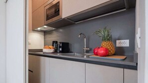 Eine moderne Küche mit Spüle, Mikrowelle und Kaffeemaschine.