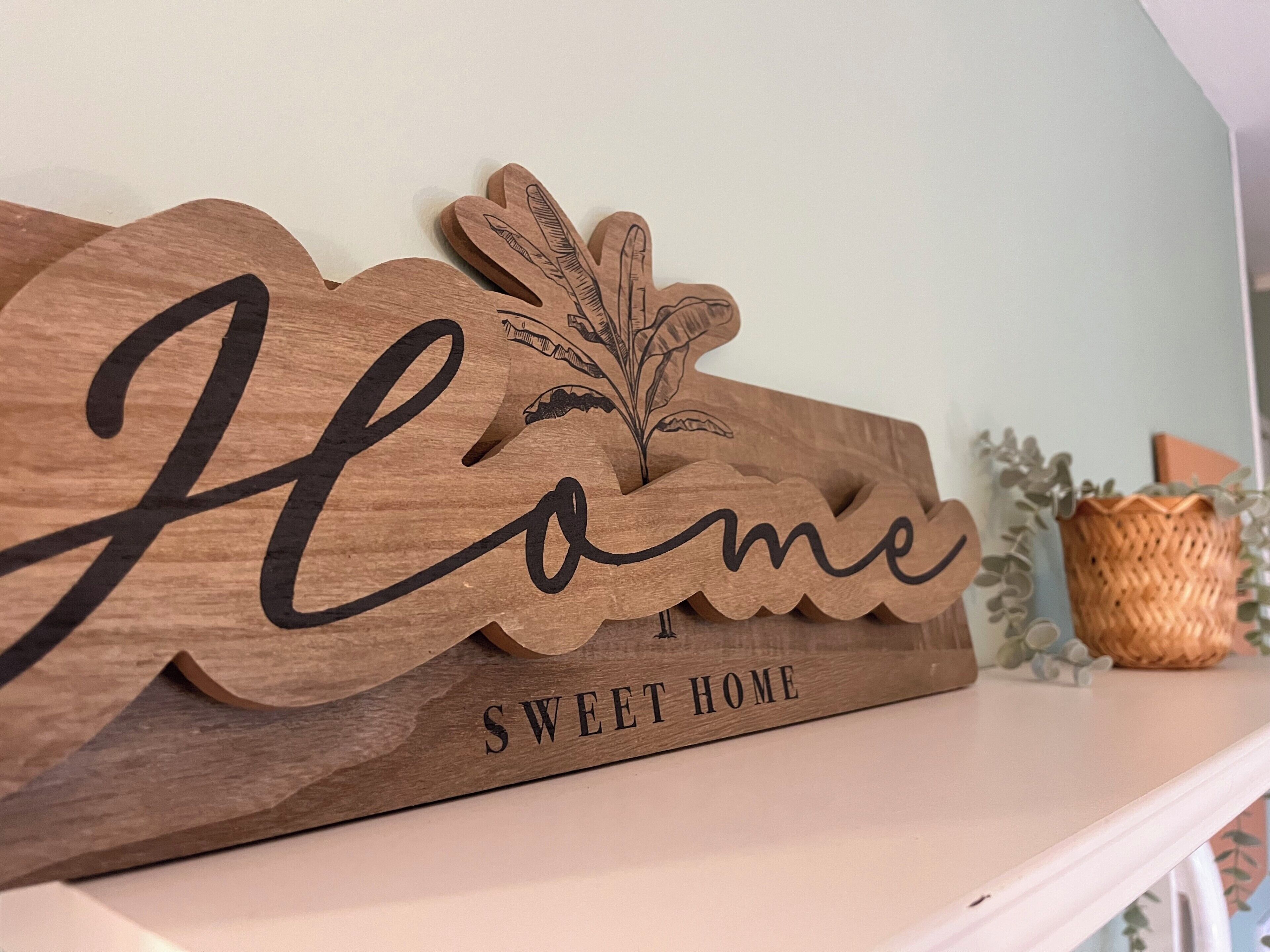 A wooden sign with the words "Home Sweet Home" and a leaf design.
