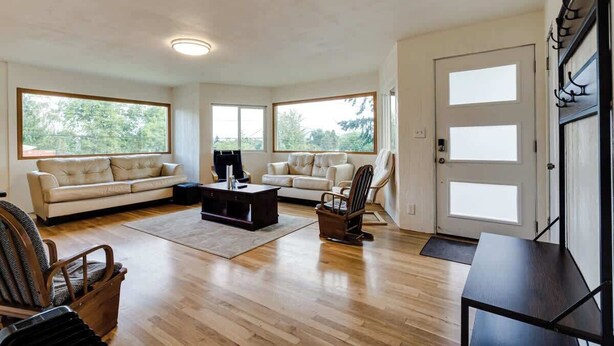 A spacious living room with two sofas, a coffee table, and a wooden floor. - Spacious 3BR • 10 Min to Autzen • Family Friendly (Eugene)