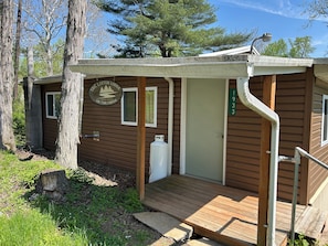 A lodge with a wooden exterior, a porch, a door, and a window.