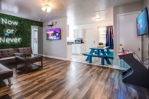 Una sala de estar moderna con un sofá, una mesa de centro y un letrero de neón.