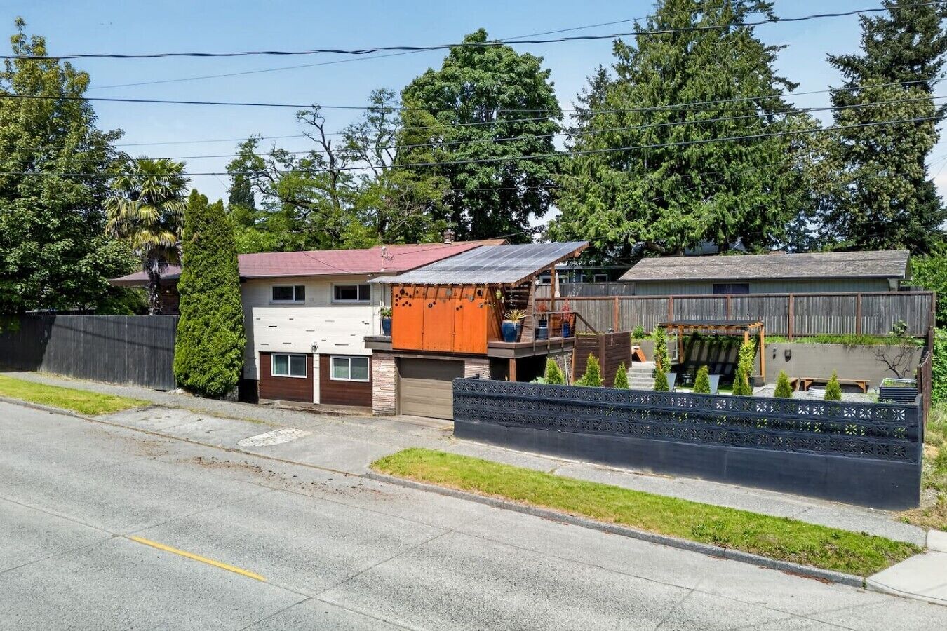 A residential property with a garage, a covered porch, and a fenced backyard.