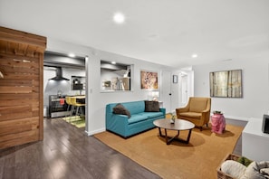 A modern living room with a sofa, armchair, and coffee table. - Deluxe West Seattle Apartment | Sleeps 6 | FIFA (Seattle)