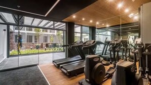 Ett gym med löpband, crosstrainers och styrketräningsmaskiner, stora fönster och utsikt över omgivningarna.