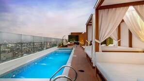 A rooftop infinity pool with a city view, sun loungers, and a glass railing. - Apartment with a beautiful view, downtown and a swimming pool (Lima)